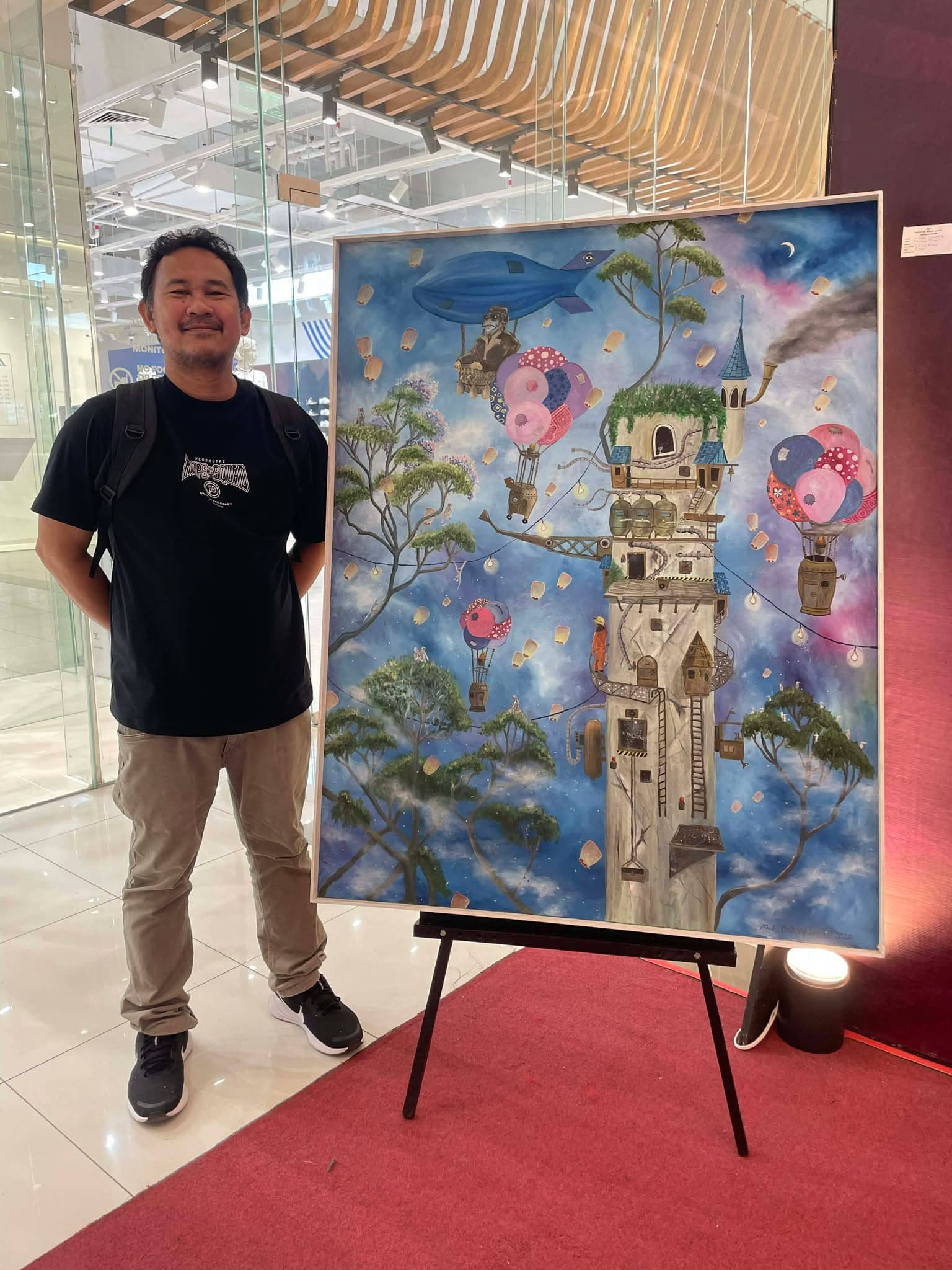 Mark standing beside one of his paintings